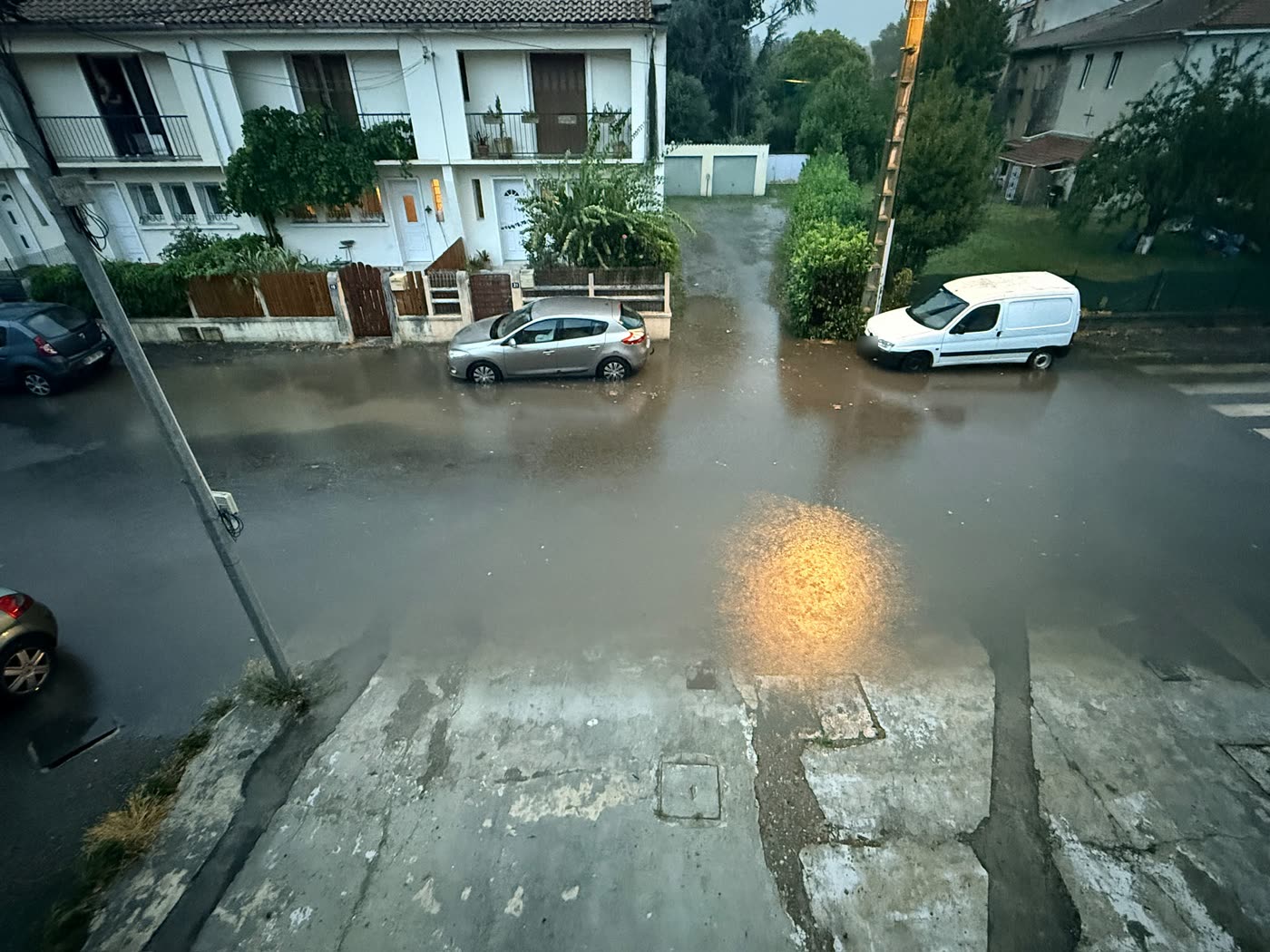 Vue d'ensemble de la rue de la Poste inondée à Gourdan-Polignan le 20 août 2026, l'eau recouvre la chaussée d'un trottoir à l'autre